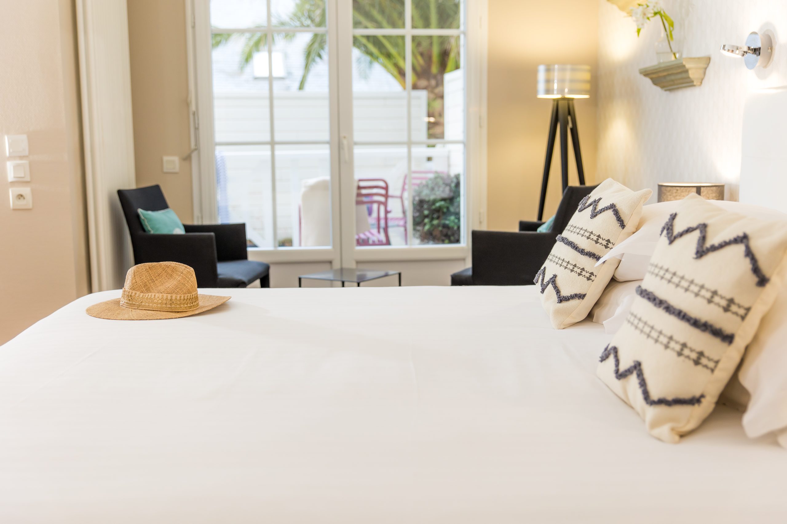 lit avec coussins décoratifs et chapeau de paille, vue sur terrasse - hotel 4 etoiles brest