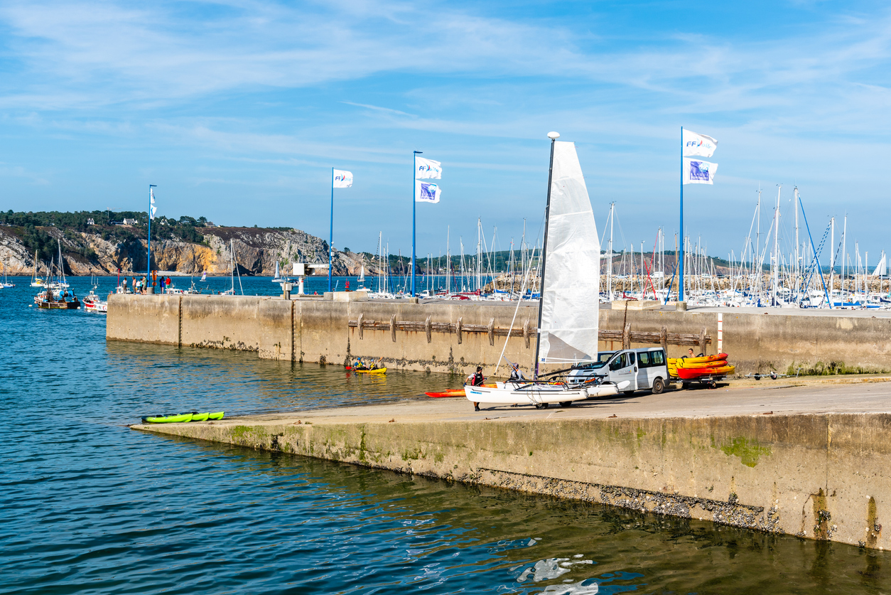 belebter Hafen mit Segelboot und Kajaks am Kai- Aufenthalt in der Bretagne